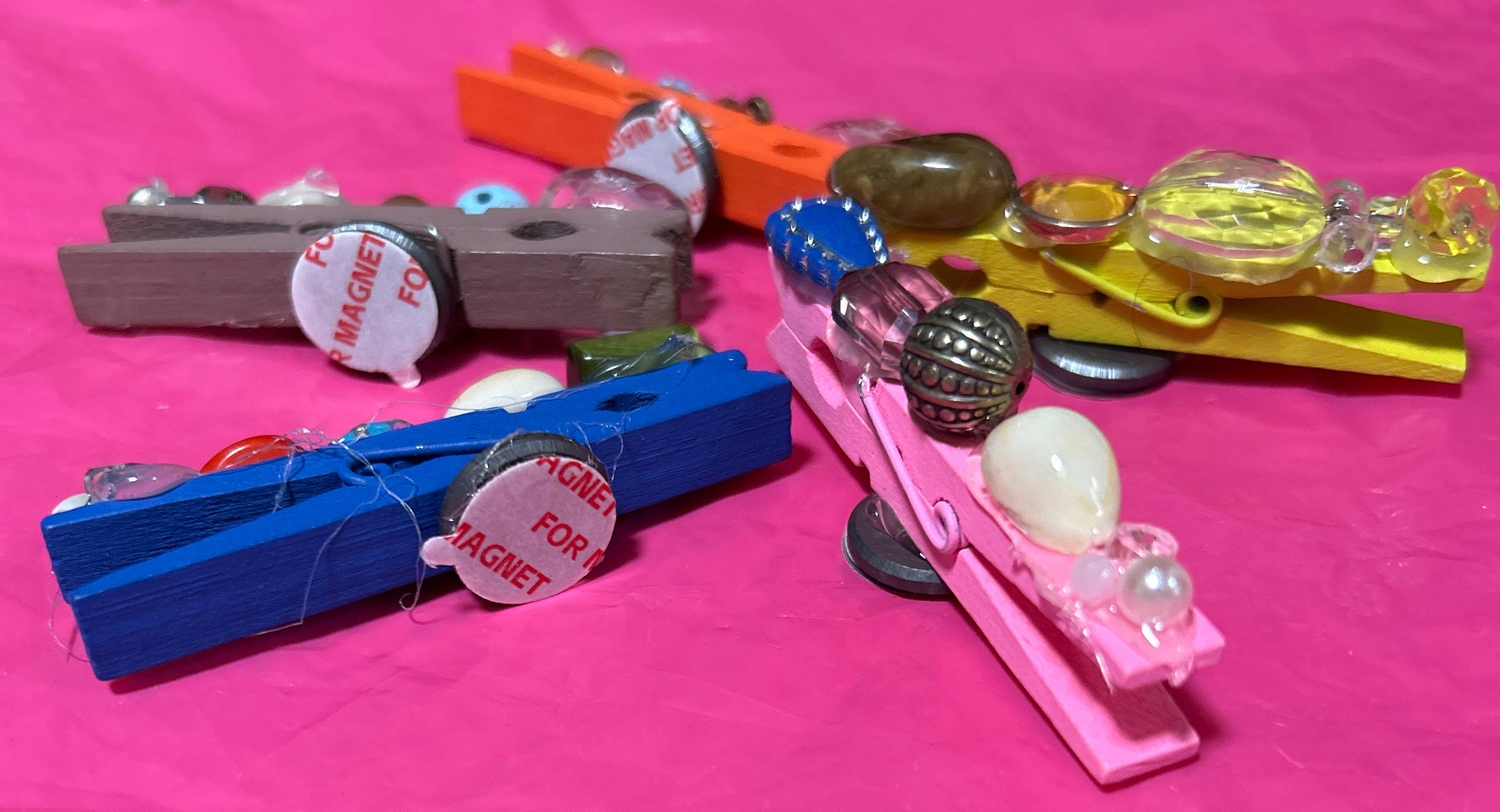 Colorful hair clips and beads on a pink background