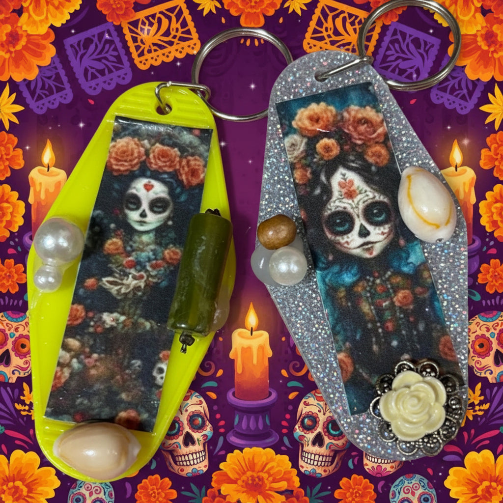 Decorative keychains with skull and floral designs on a pink surface