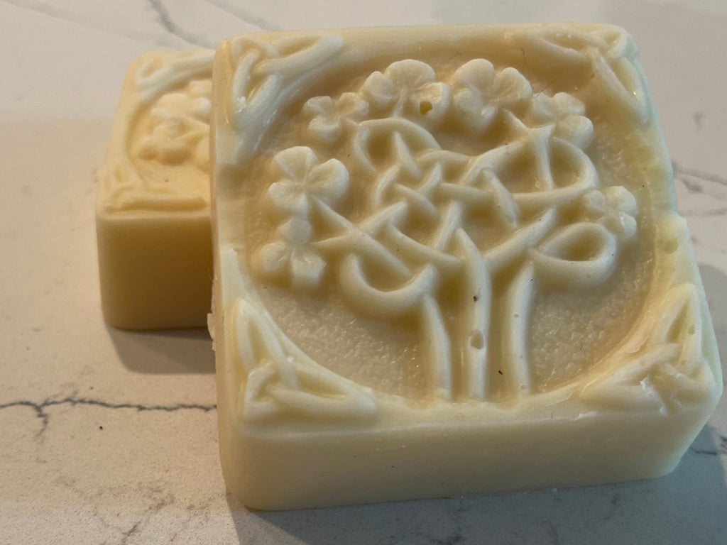 Two soap bars with floral designs on a marble surface