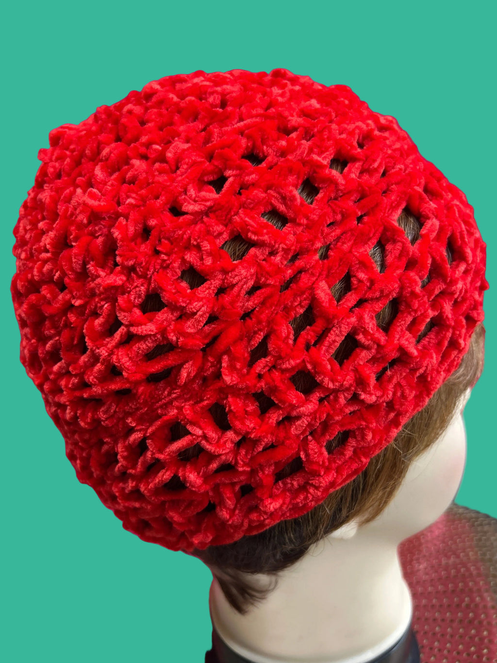 Red knitted headscarf on a mannequin head with a blurred background