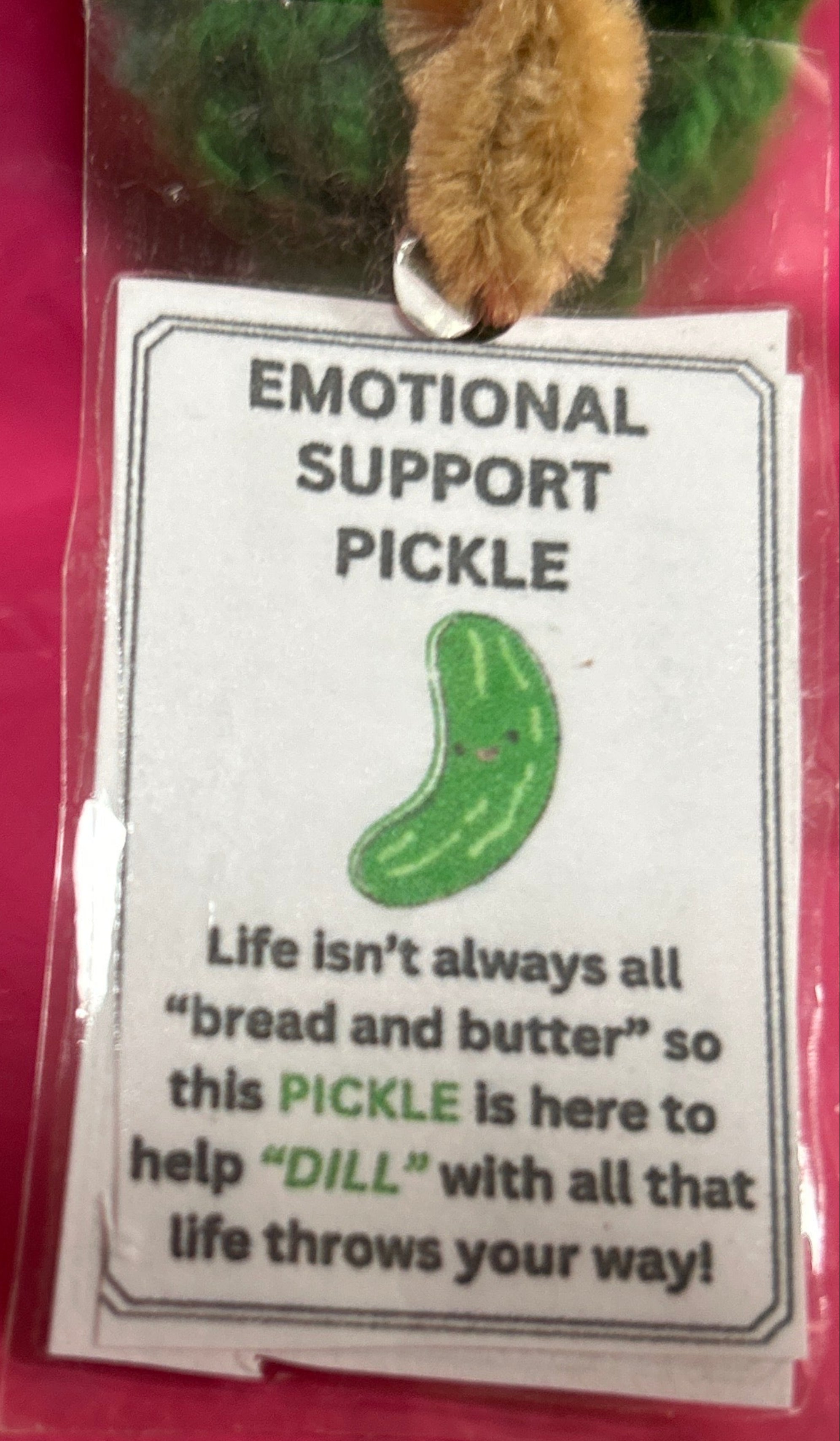 Emotional support pickle with a tag on a pink background