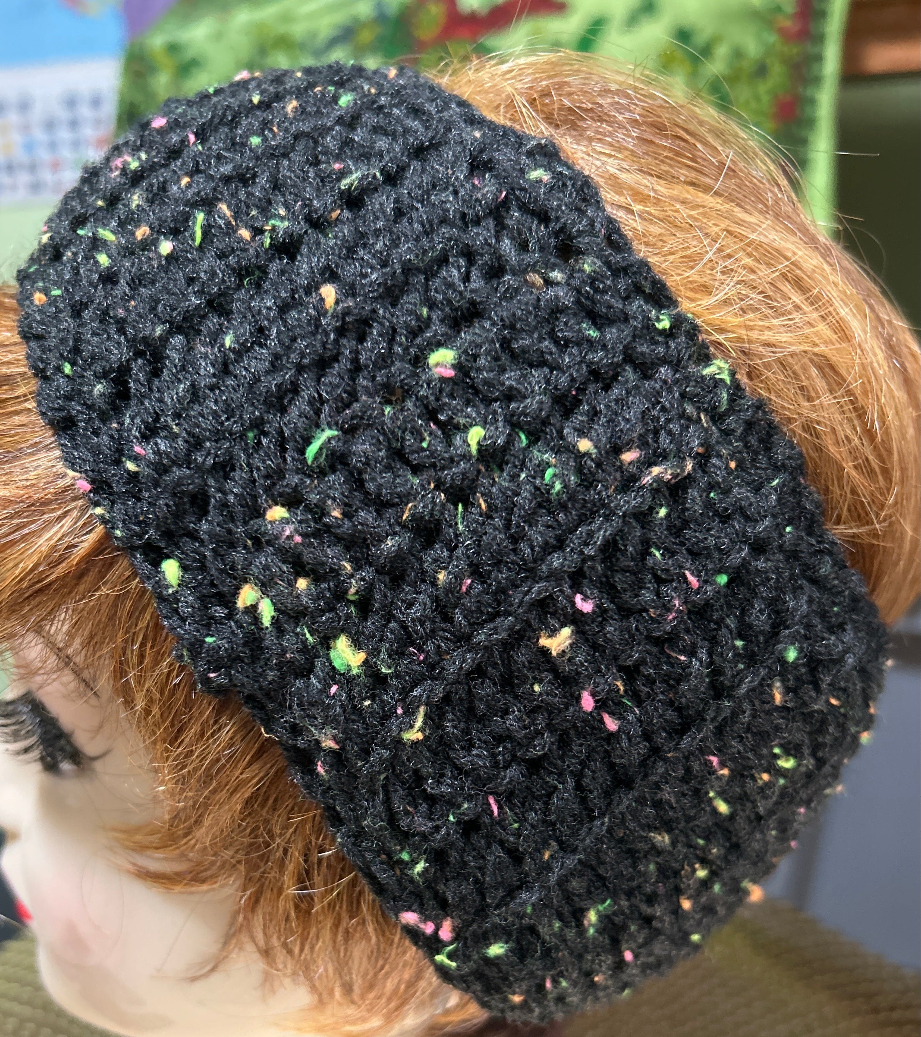 Black knitted headband on a mannequin head with a blurred background