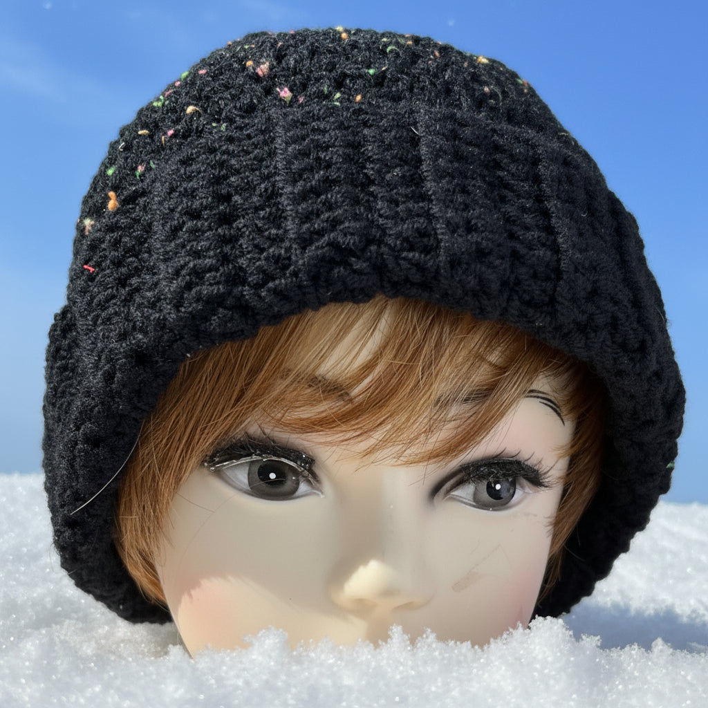Mannequin head wearing a black knitted hat with a blurred background