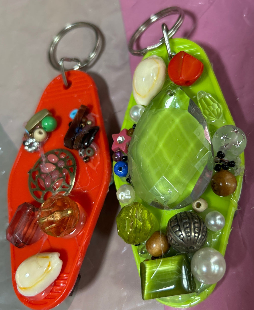 Colorful keychain with various beads and charms on a pink and gray background