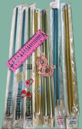 Set of metal knitting needles in packaging on a green surface