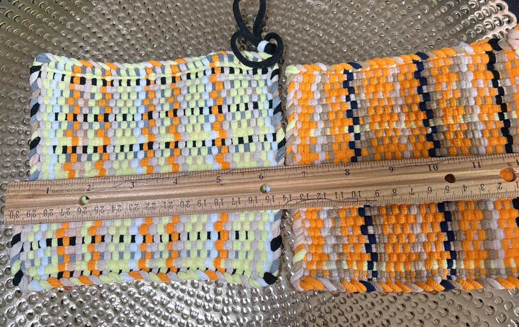 Colorful woven belt with a ruler for scale on a textured surface
