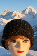 Mannequin head wearing a black textured hat with a blurred background