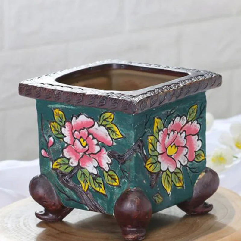 Decorative ceramic pot with floral design on a white background