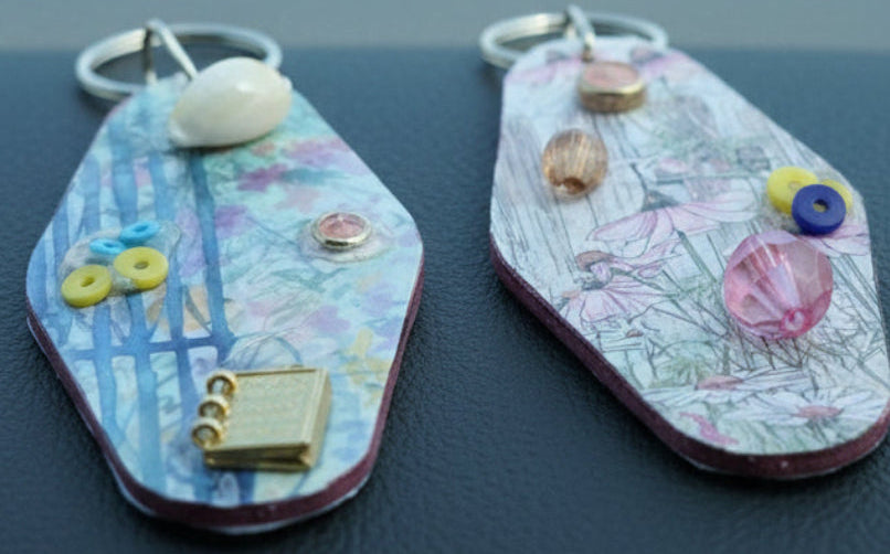 Two decorative keychains on a textured surface