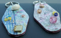 Two decorative keychains on a textured surface