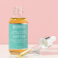Laguna Herbals bottle of herbal infused bath and body oil with dropper on a pink background