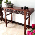 Wooden console table with decorative elements on a white wall background