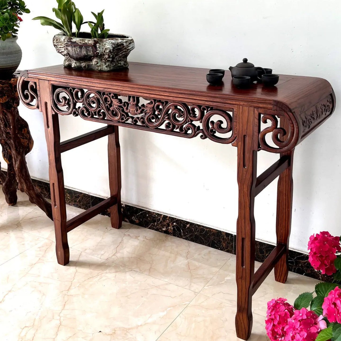 Wooden console table with decorative elements on a white wall background