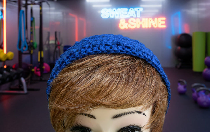 Mannequin head with a blue knitted headband on a green surface