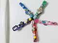 Colorful beaded hair clips on a textured surface