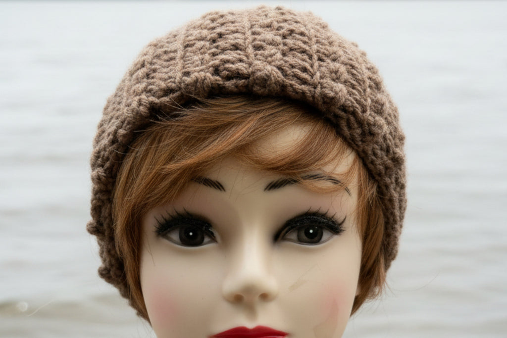 Mannequin head wearing a brown knitted hat on a green background