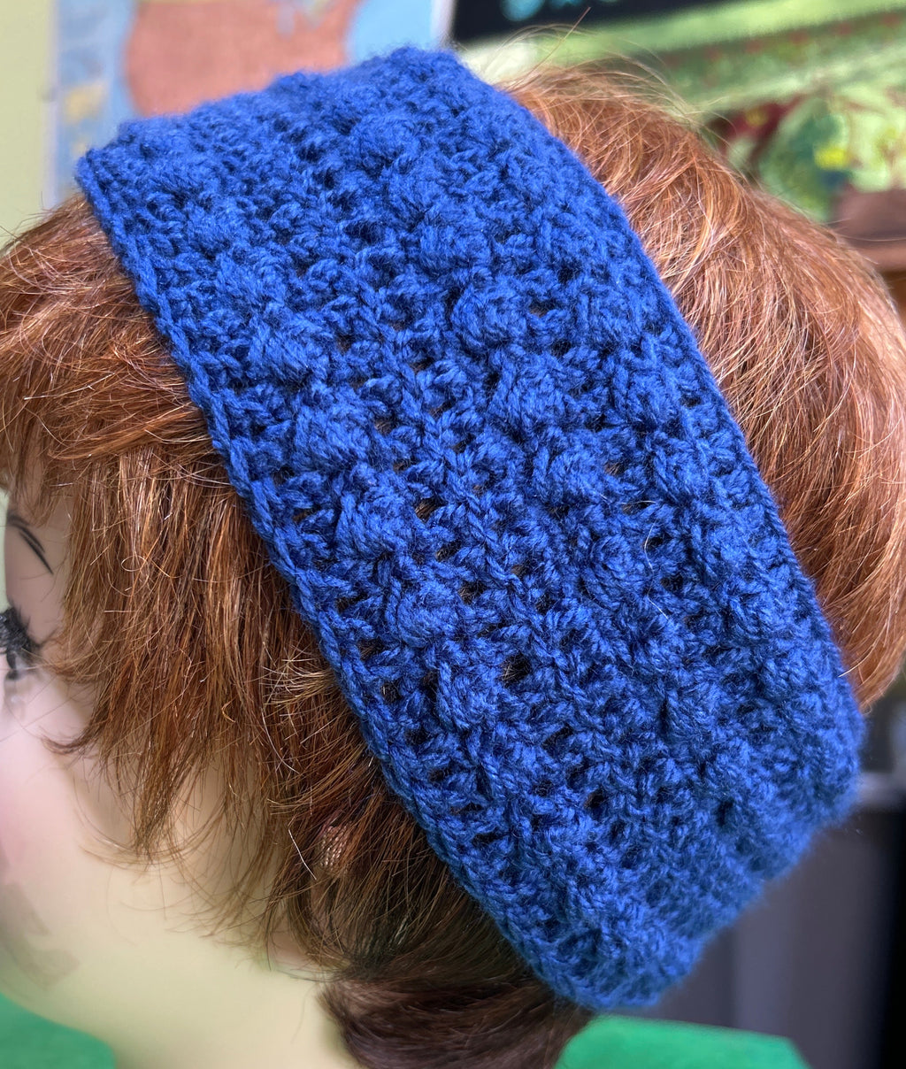 Person wearing a blue knitted headband with a blurred background