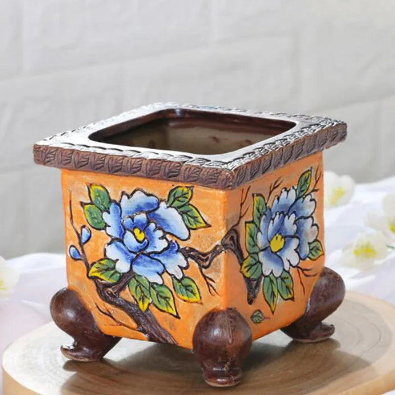 Decorative ceramic pot with floral design on a wooden surface