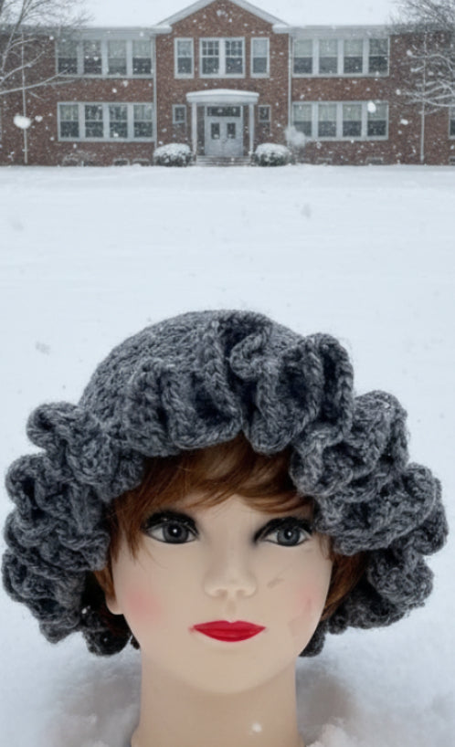 Mannequin head with a gray knitted headband on a textured surface