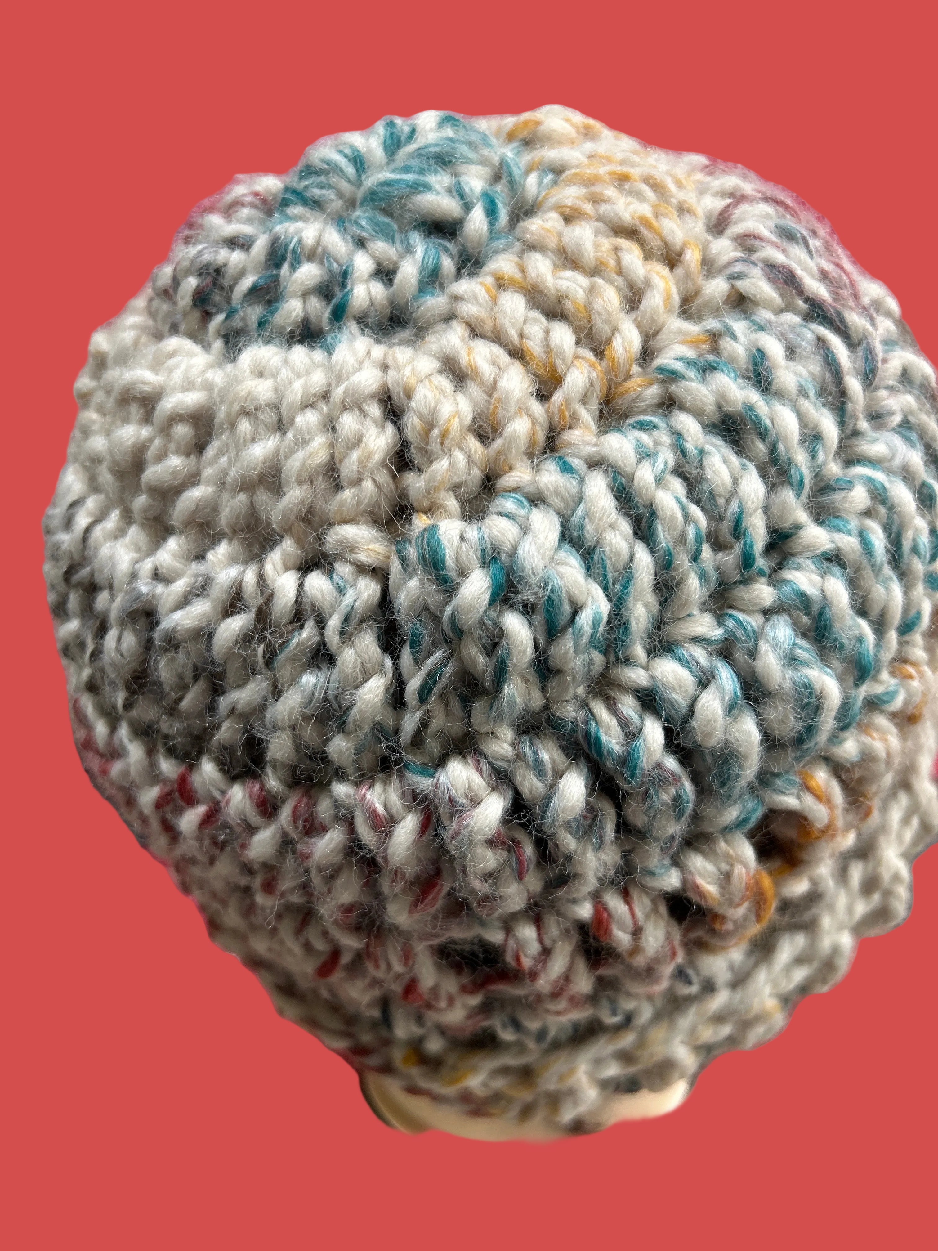 Textured ball of yarn on a pink background
