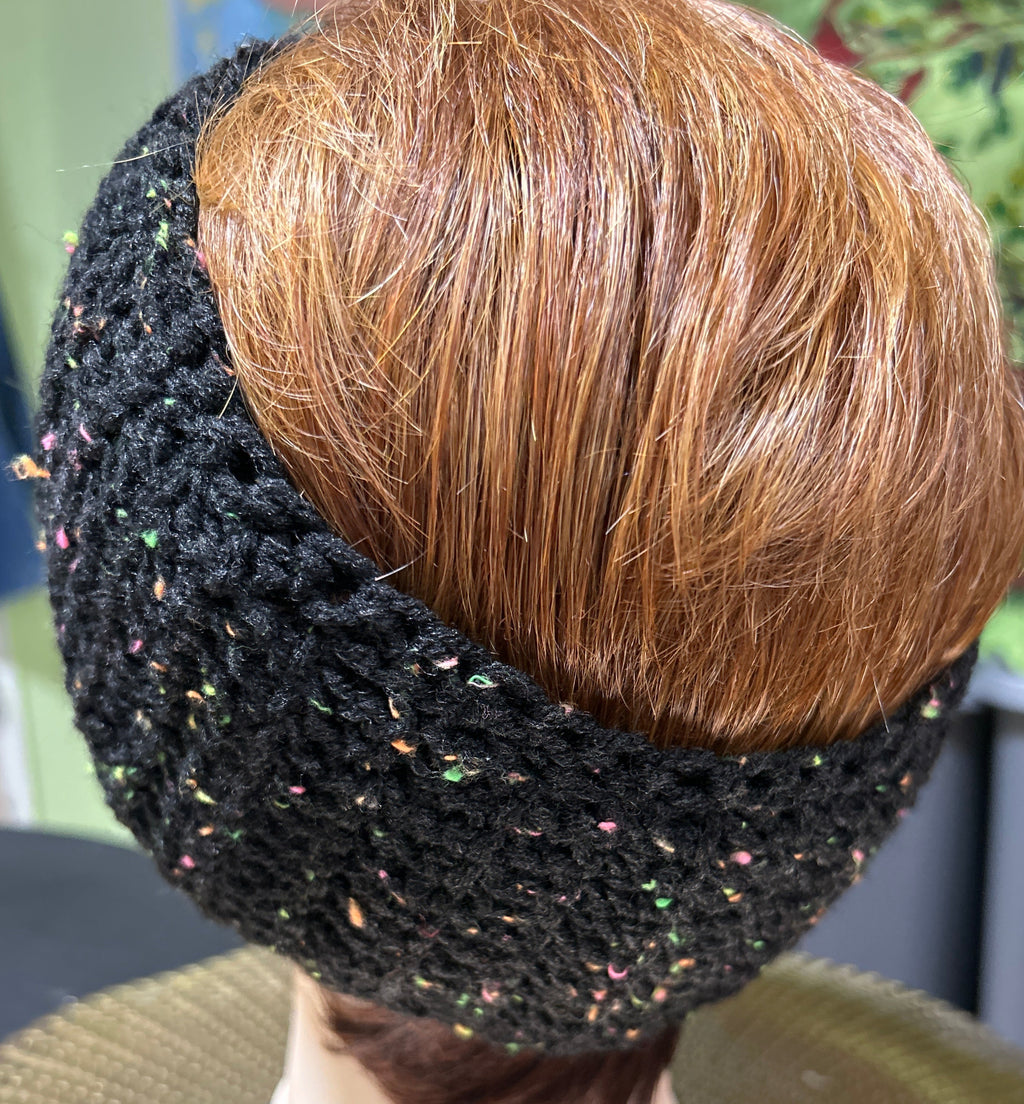 Close-up of a black knitted headband with brown hair on a blurred background