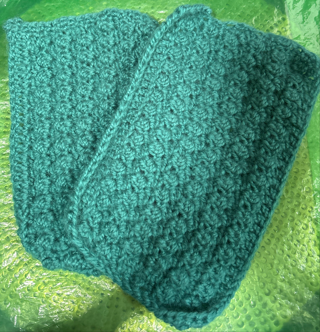 Green knitted fabric on a green textured surface