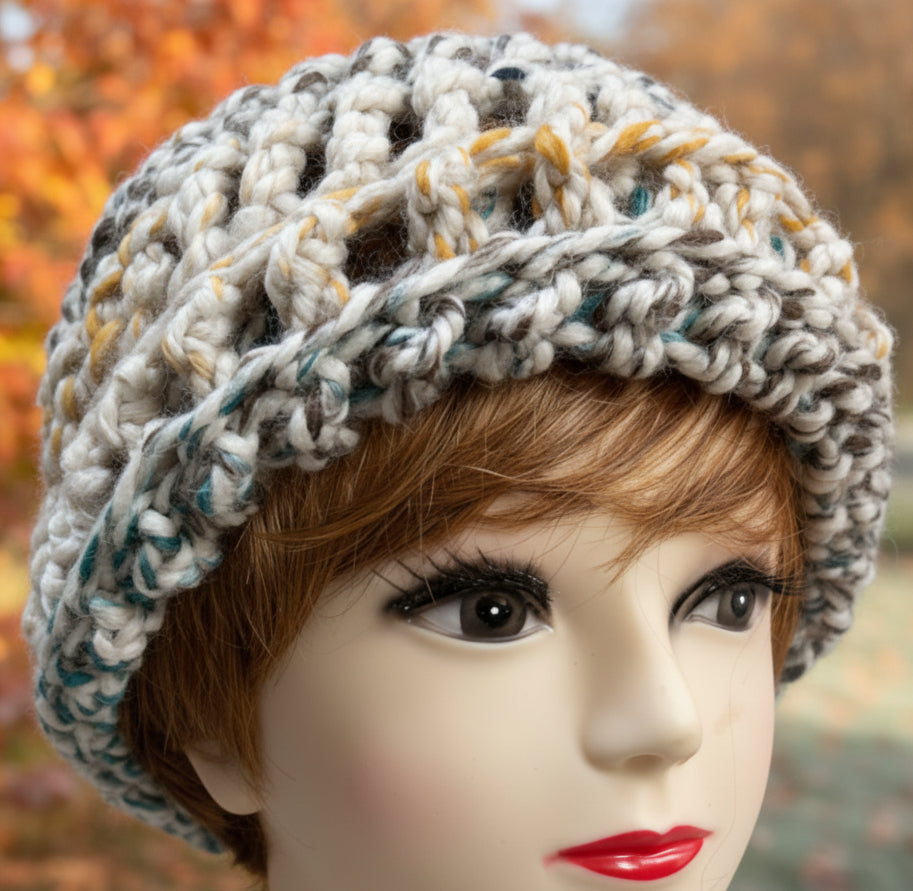 Mannequin head wearing a knitted gray beanie against a pink background