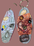 Two decorative keychains on a textured surface