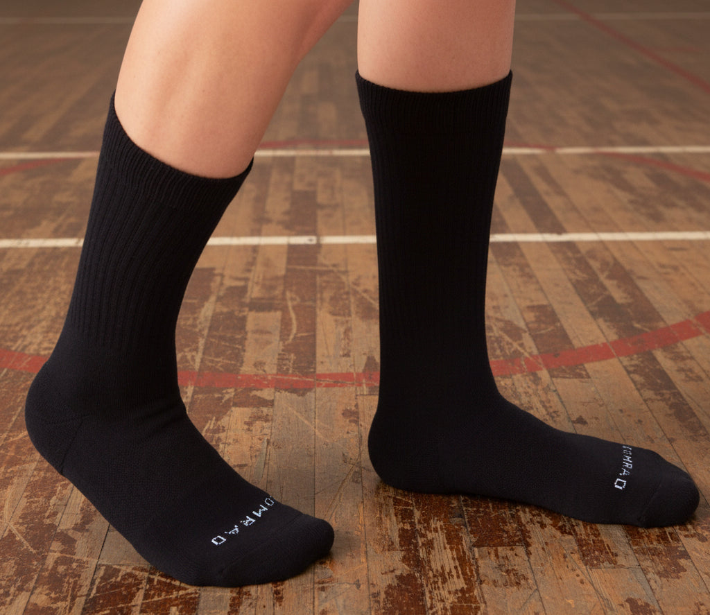 Black socks worn by a person on a white background