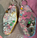Floral keychain with decorative beads on a clear surface