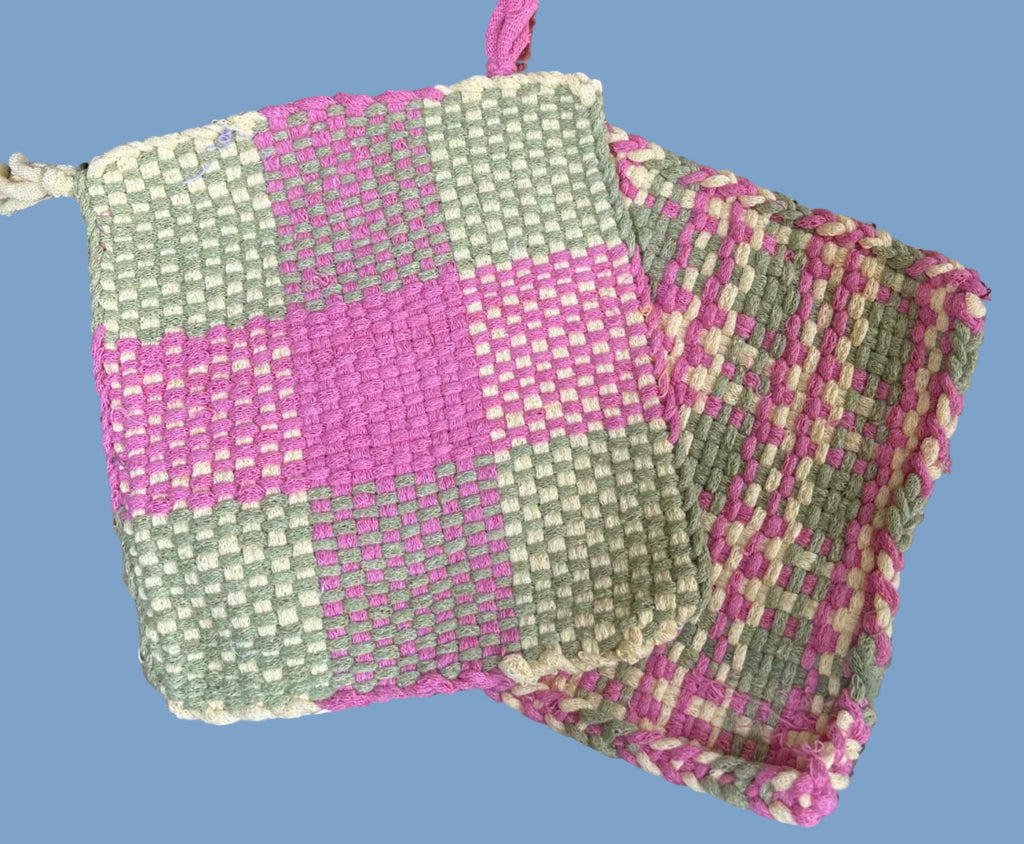 Hand-woven pink and green fabric on a metal surface