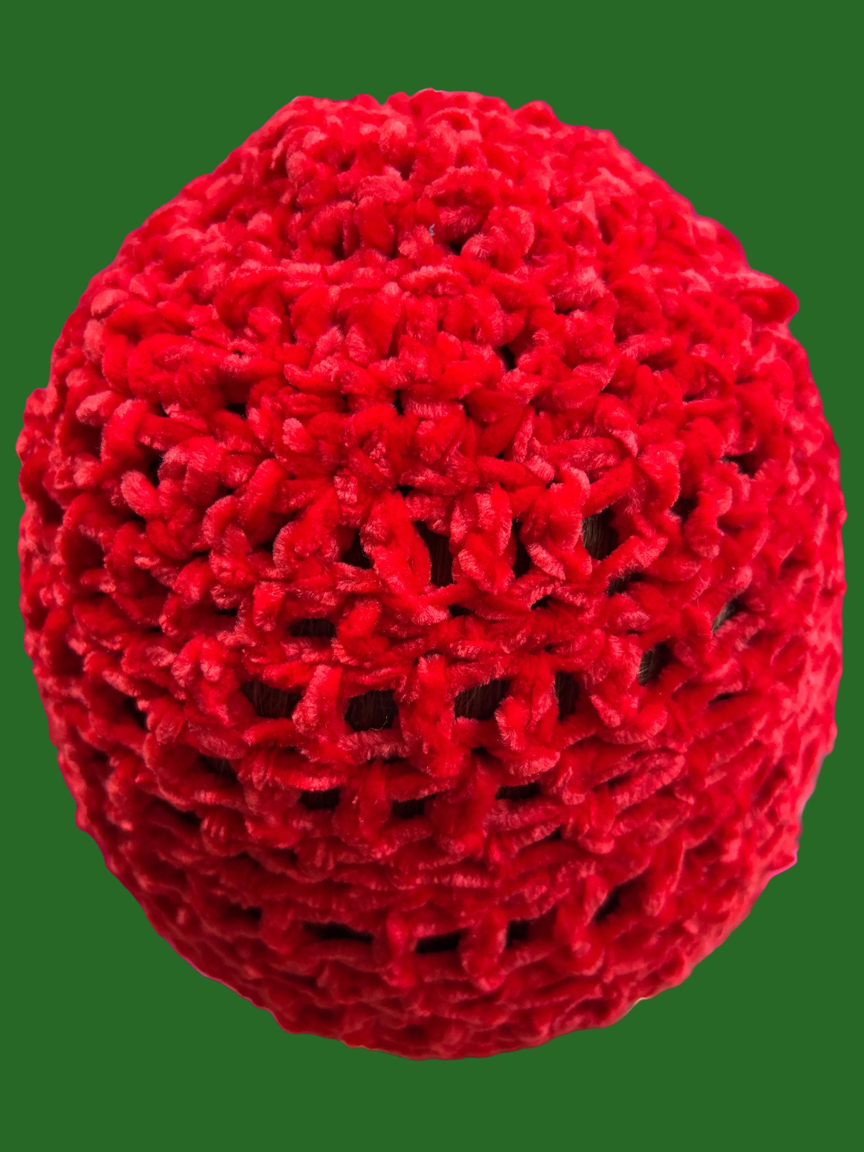Red textured ball held by a hand with a blurred background