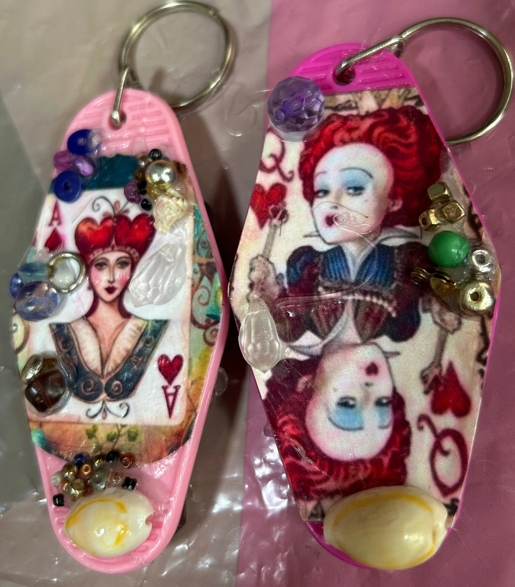 Two decorative keychains with cartoon character designs on a pink and white background.