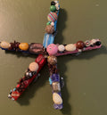 Decorative dragonfly with multicolored beads on a textured surface