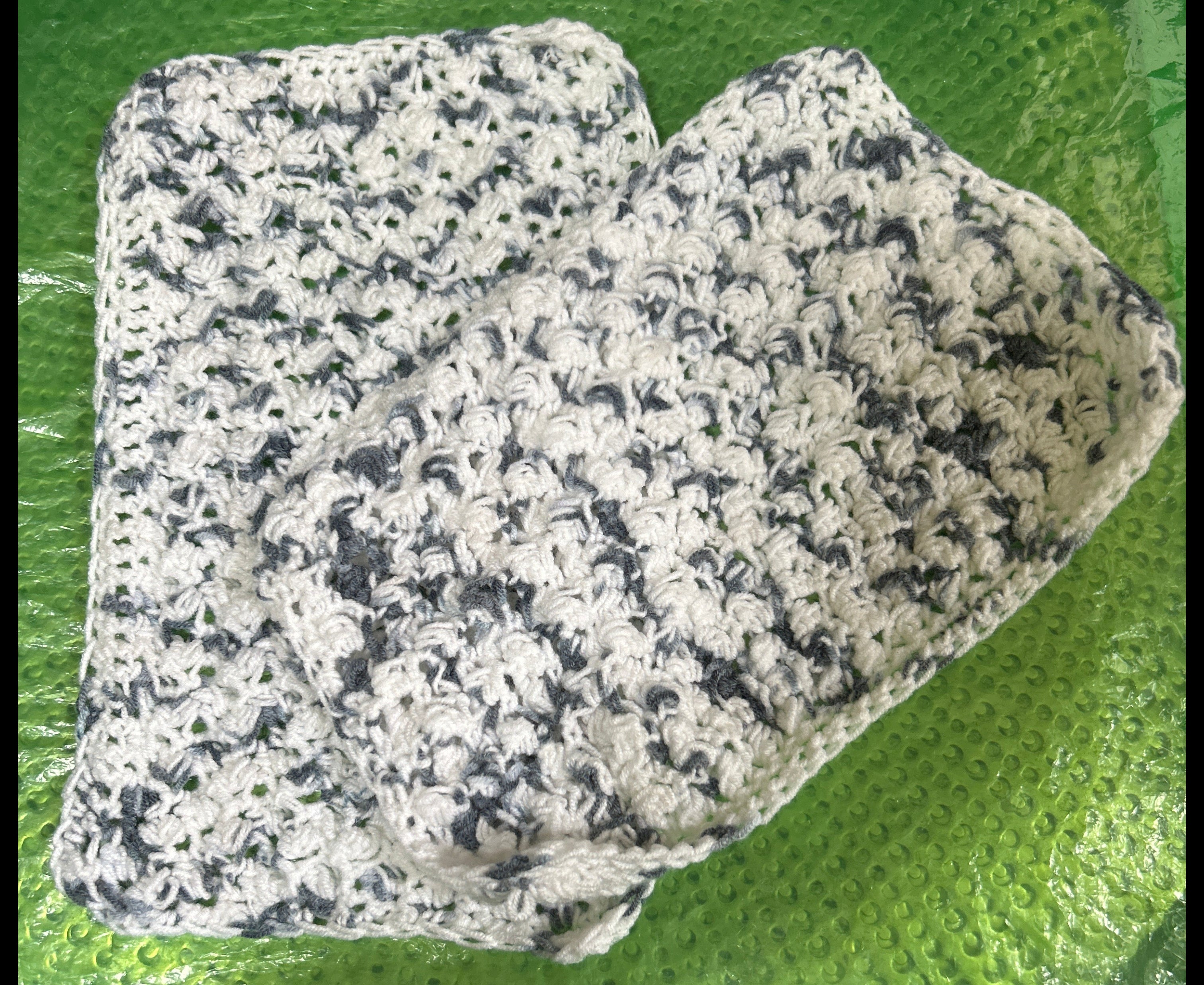 White and black patterned fabric on a green textured surface