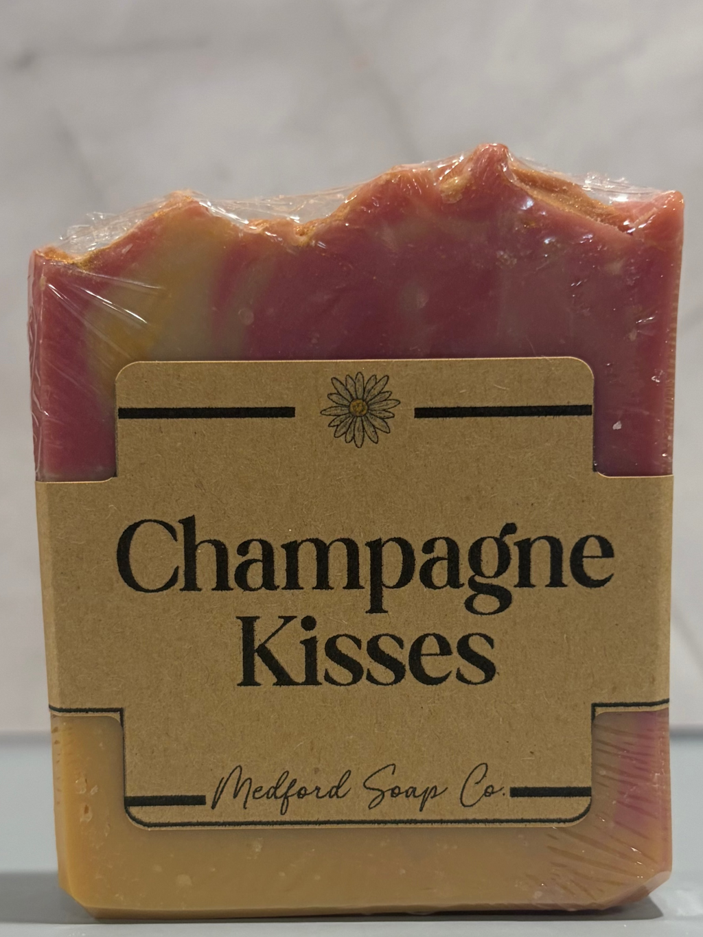 Bar of soap with a clear wrapper labeled 'Champagne Kisses' from Medford Soap Co.