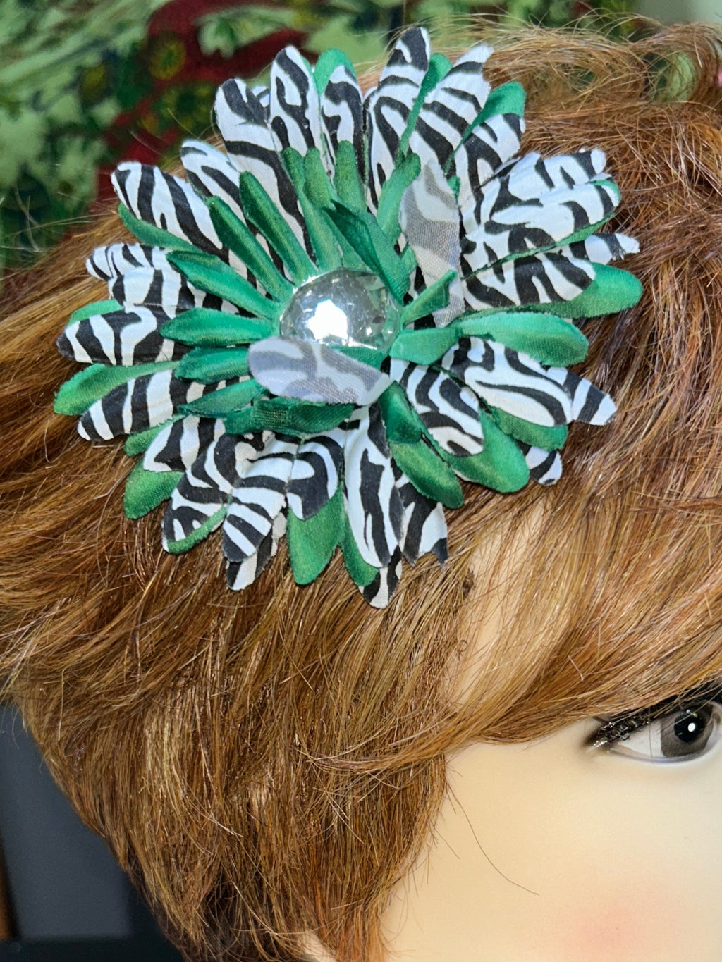 Mannequin head with brown hair and decorative flower accessory, blurred background