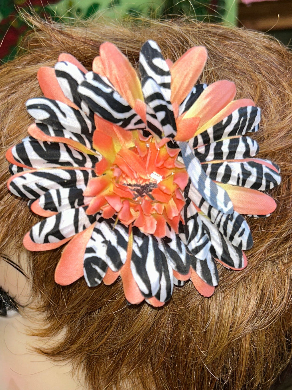 Mannequin head with decorative hair clip on a blurred indoor background