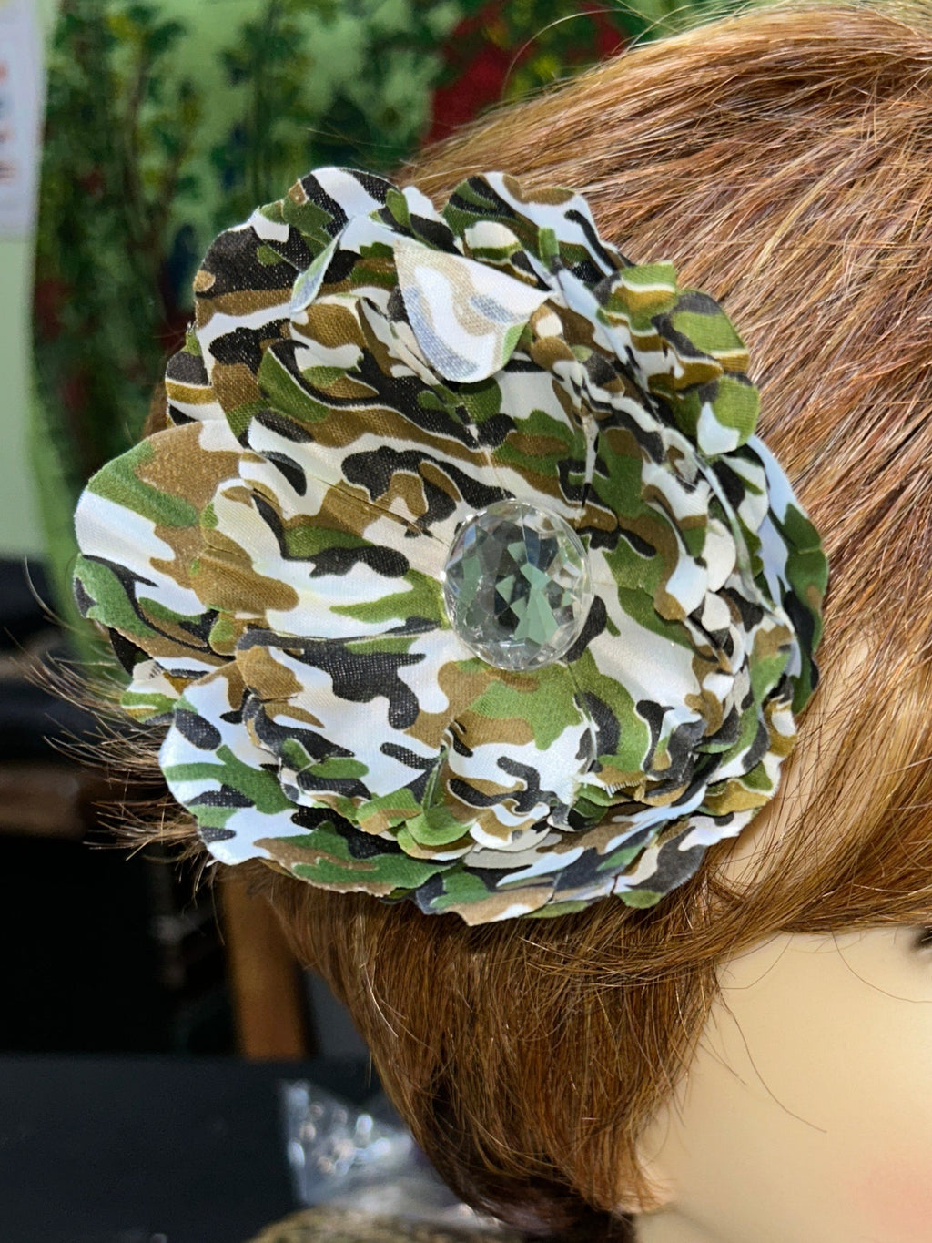 Mannequin head with a camouflage-patterned headband on a blurred background