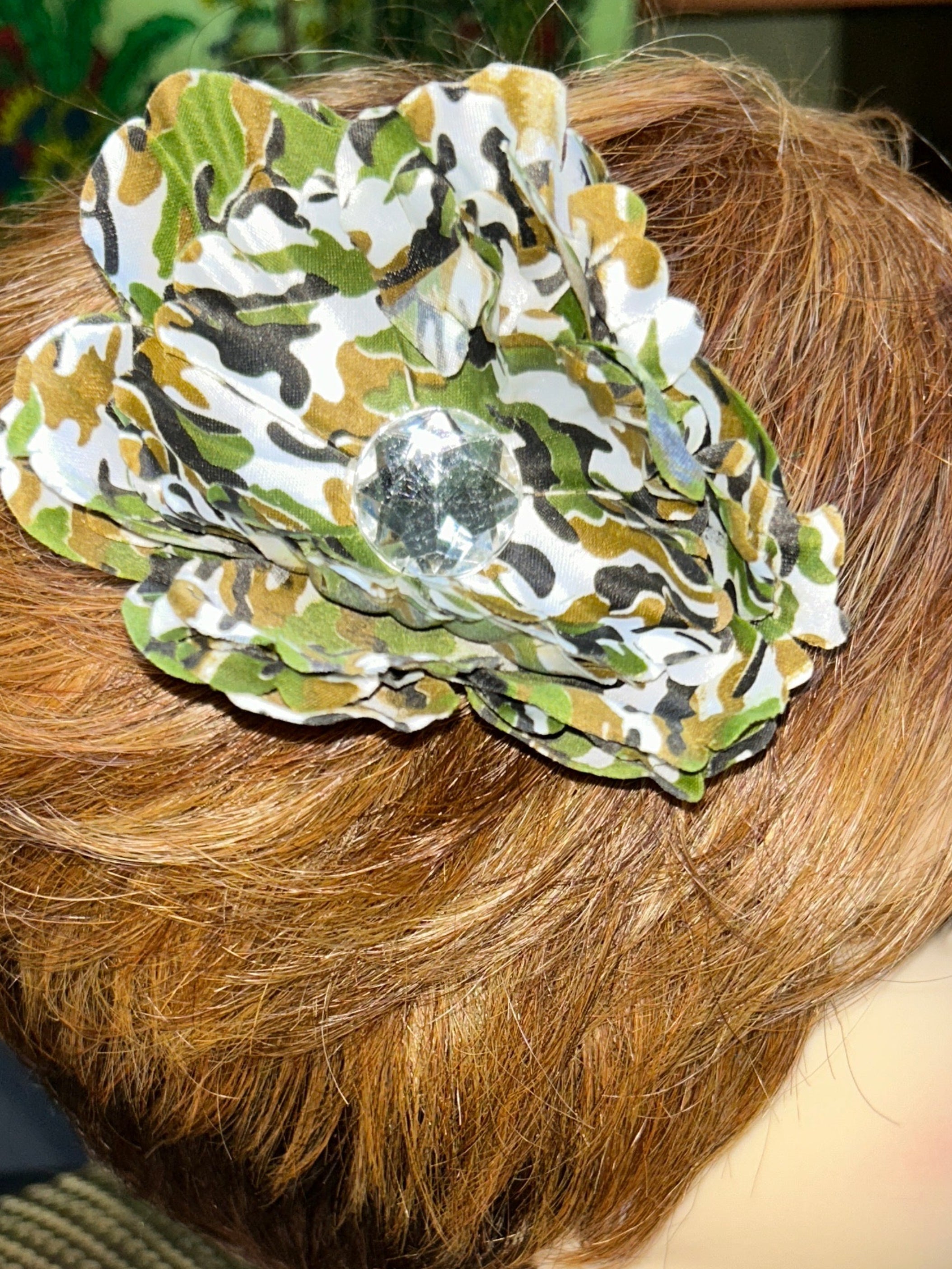 Mannequin head with decorative hair clip and large decorative headpiece.