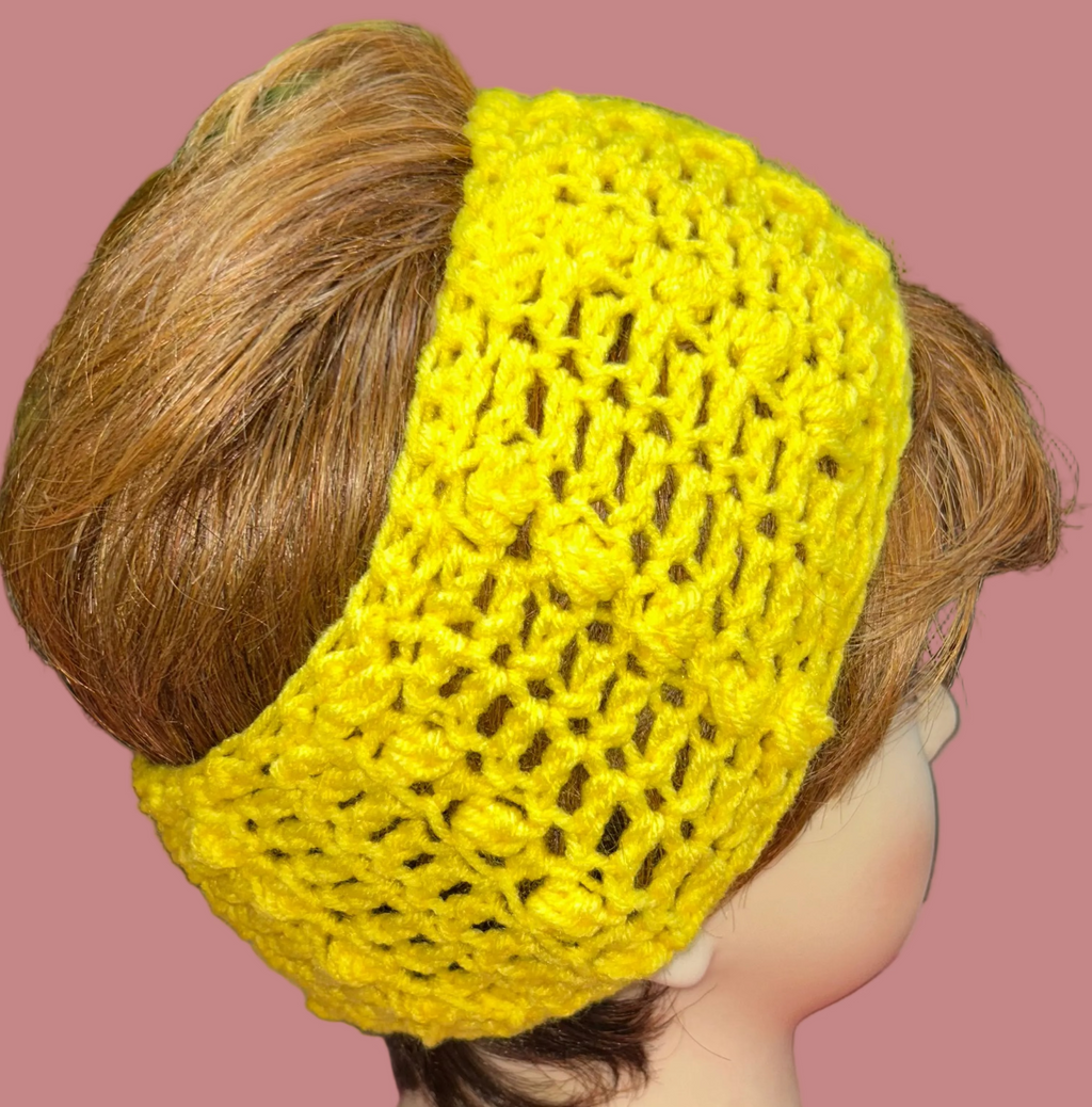 Yellow crocheted headband on a mannequin head with a colorful background