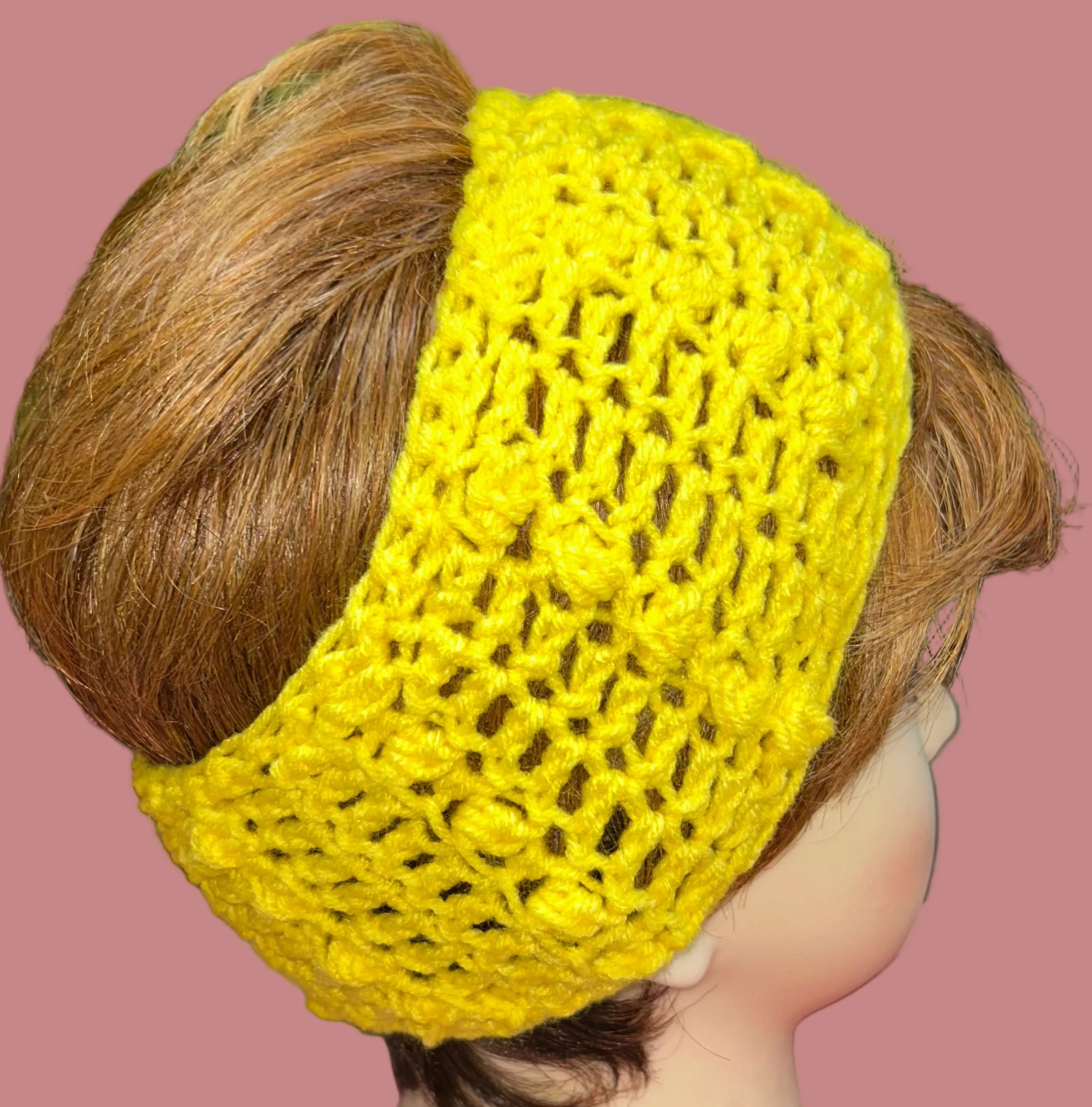 Yellow crocheted headband on a mannequin head with a colorful background