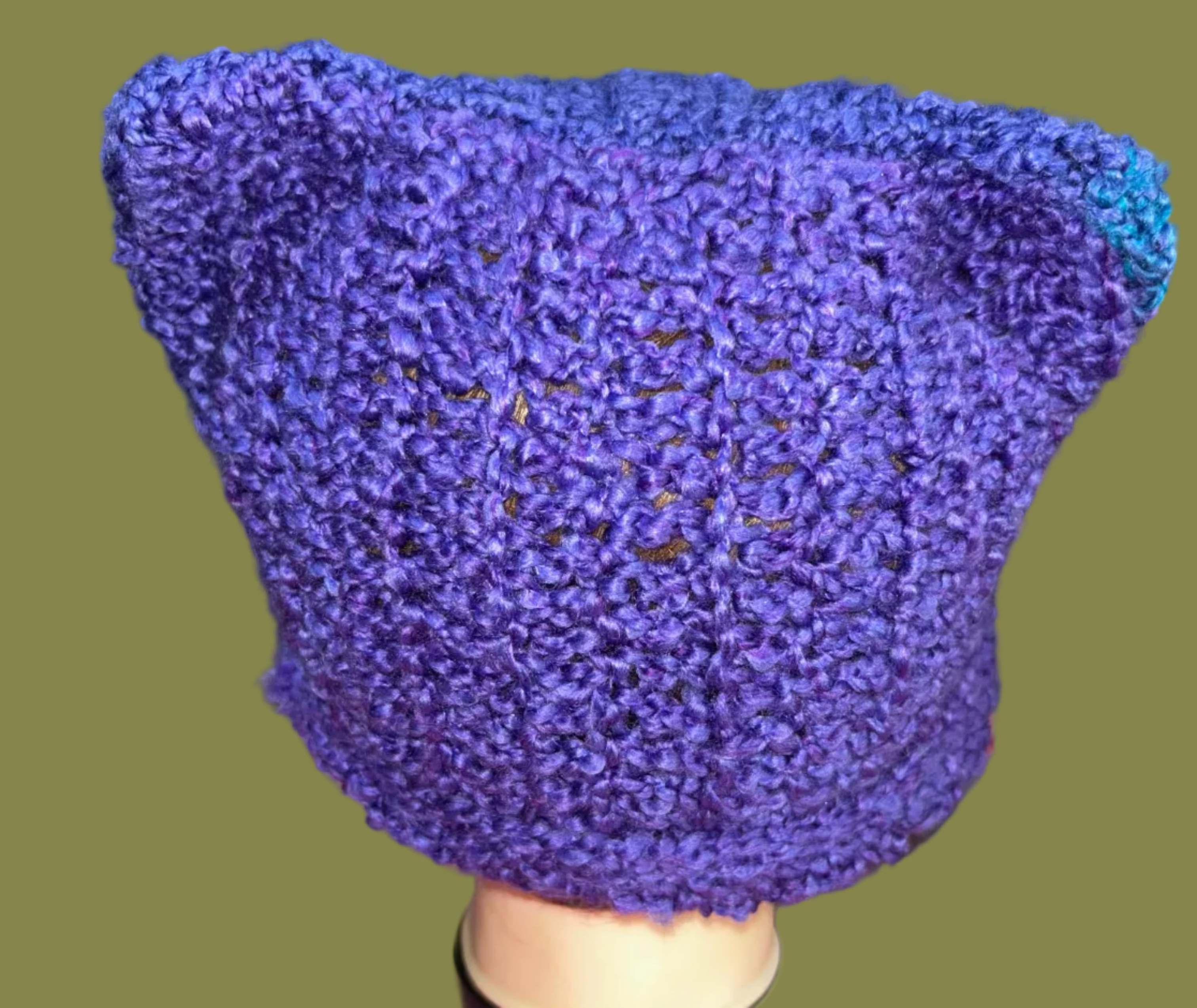 Blue crocheted beanie
 on a mannequin head with a blurred background