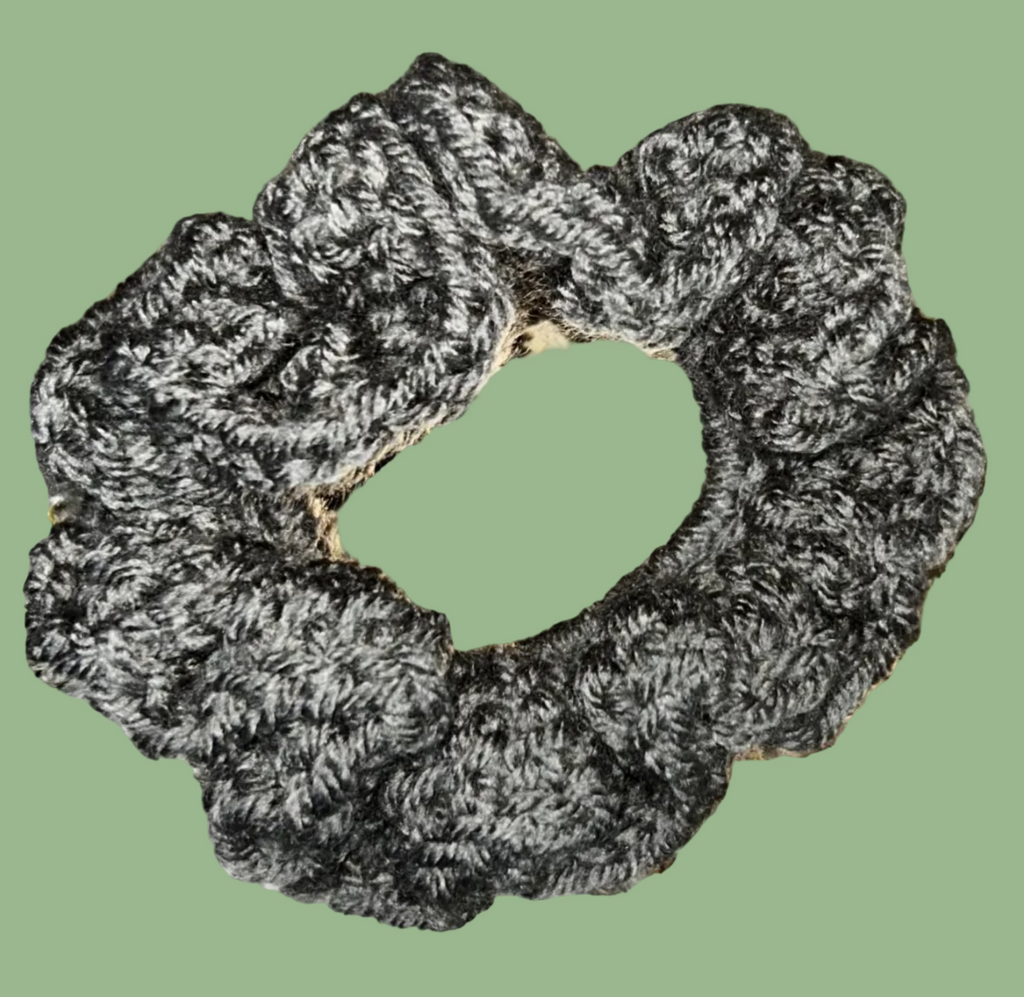 Two gray scrunchies on a textured gold surface