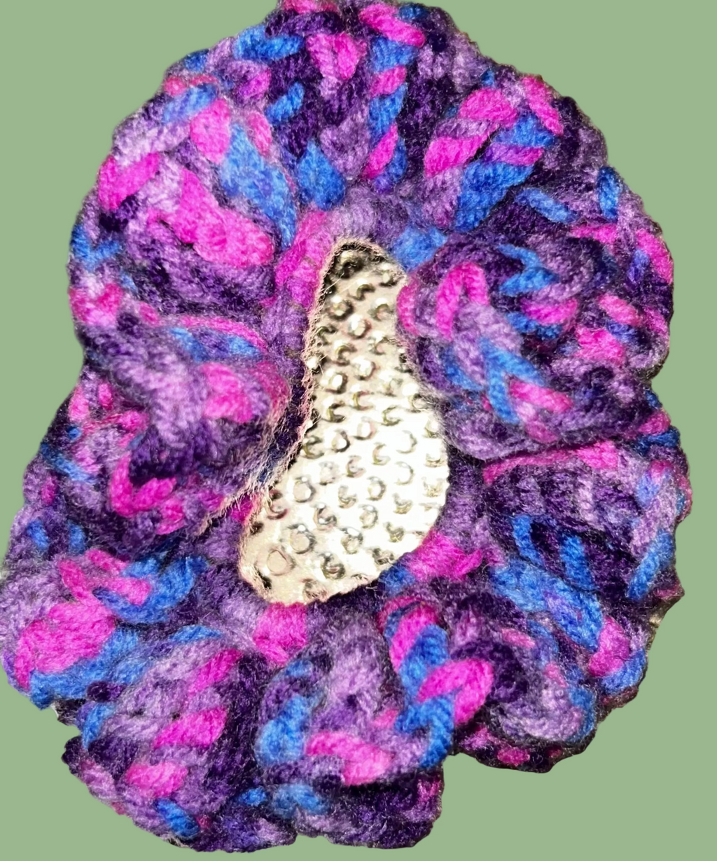 Multicolored scrunchie with a decorative element on a textured gold background