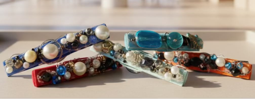 Decorative brooch with multicolored beads on a textured metallic surface