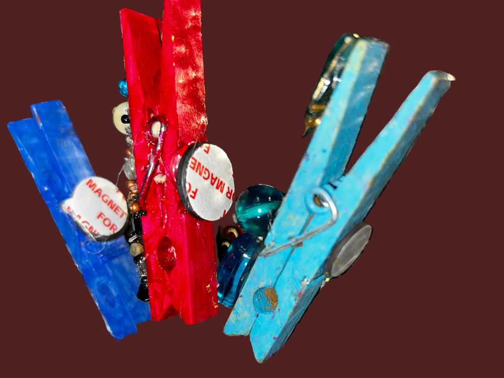 Colorful clothespins with decorative elements on a textured surface