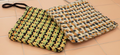 Checkered potholders on a pink surface 