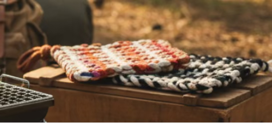 Two woven coasters on a striped fabric background