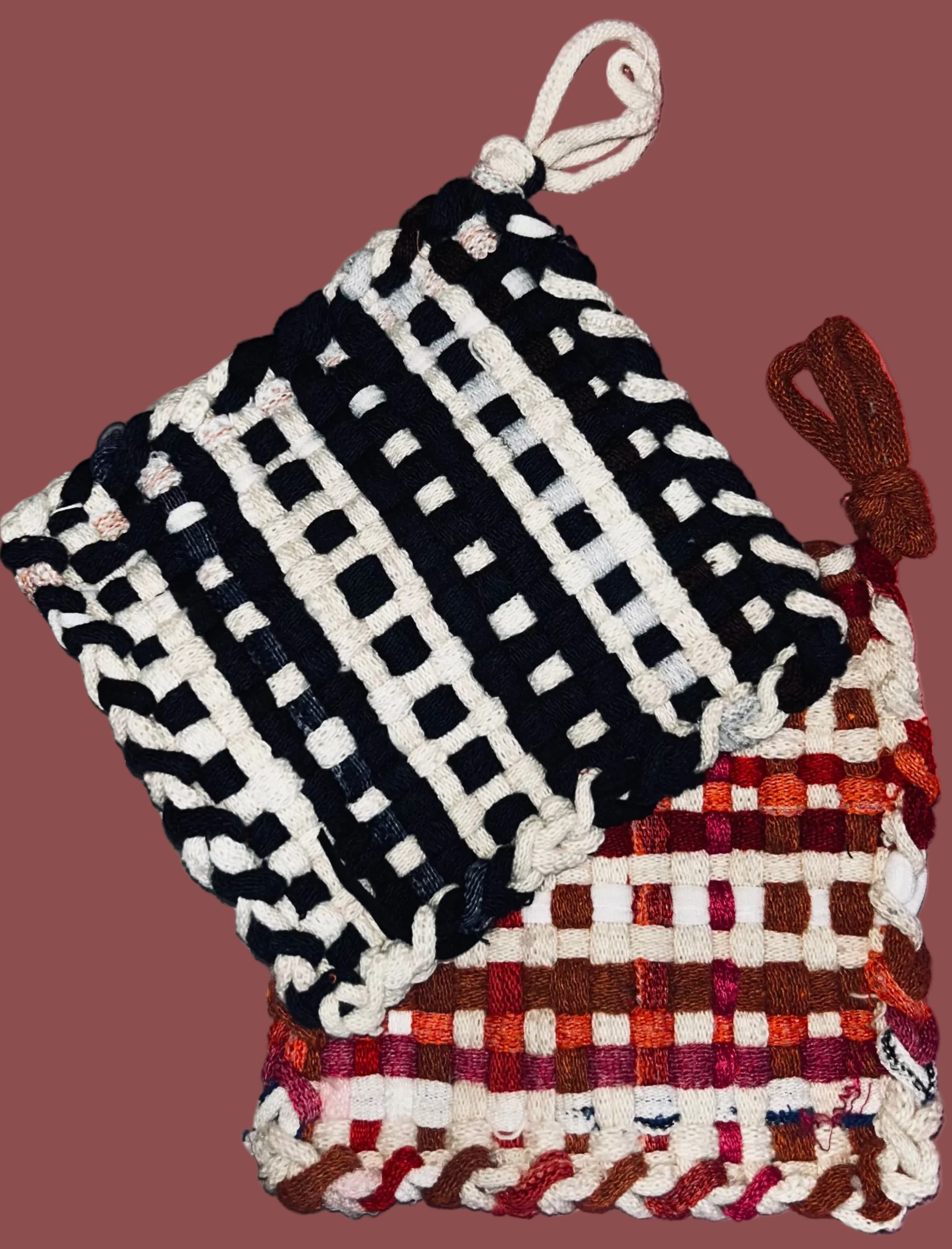 Black and white checkered potholders with a red and white pattern on a pink background